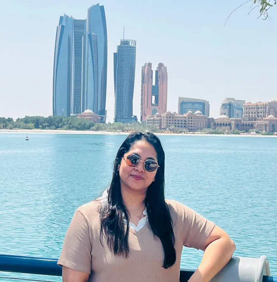 Alida Mohan top rated Digital Marketing Specialist in Dubai UAE standing at Dubai waterfront with city skyline.